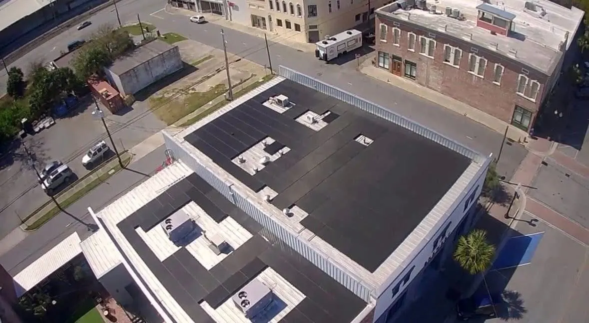 Aerial view of a downtown commercial building with a flat-roof solar install
