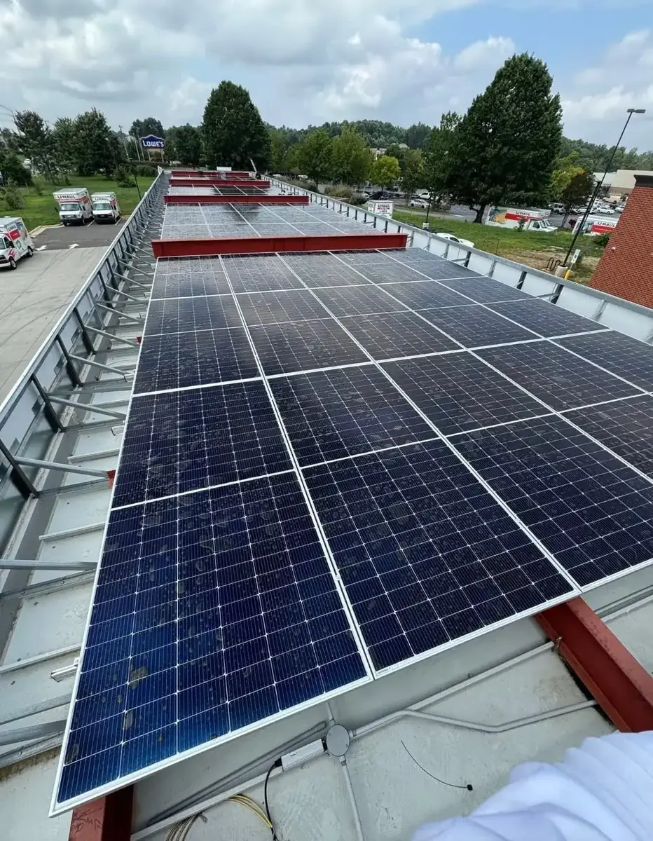 Rows of tilt-mounted solar panels on a commercial building rooftop