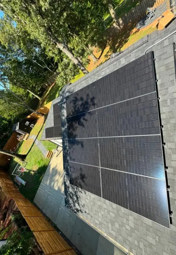 Neatly aligned black solar panels on a residential shingle roof